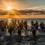 Captured during a triathlon event, athletes enter the sea at sunrise in Alicante, Spain.